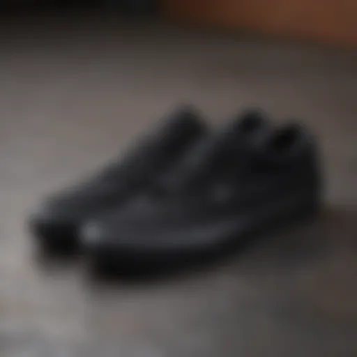 A close-up of all black low top Vans on a skateboard