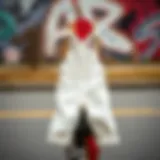 A pair of white denim overalls hanging on a skateboard