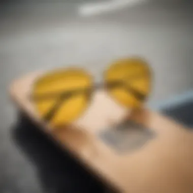 Close-up of yellow aviator sunglasses on a skateboard deck