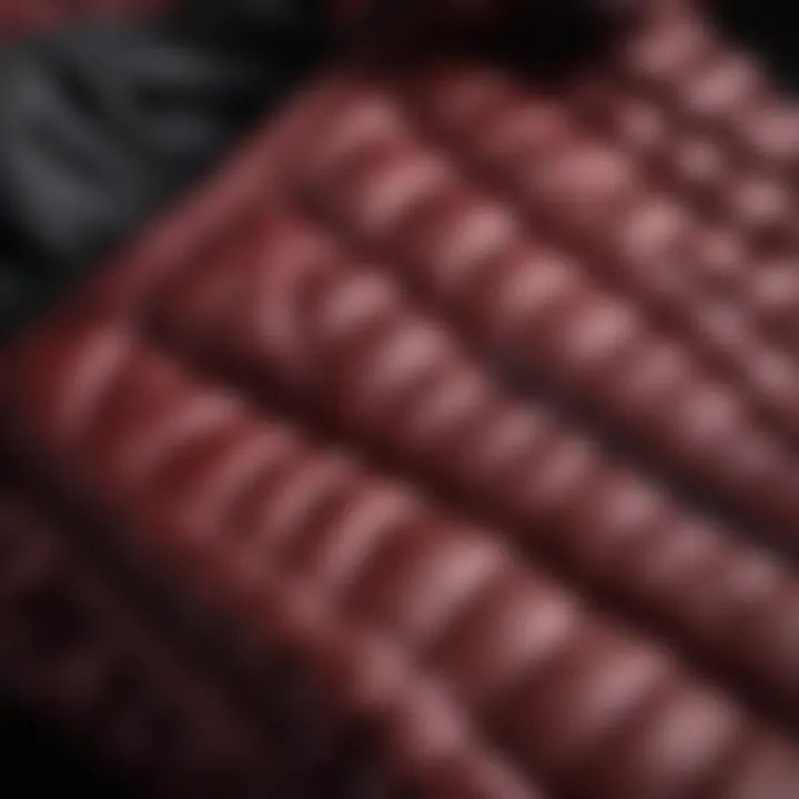 Close-up of the stitching and fabrication details of a burgundy puffer jacket, emphasizing craftsmanship.