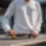 Close-up of a long sleeve white tee draped over a skateboard